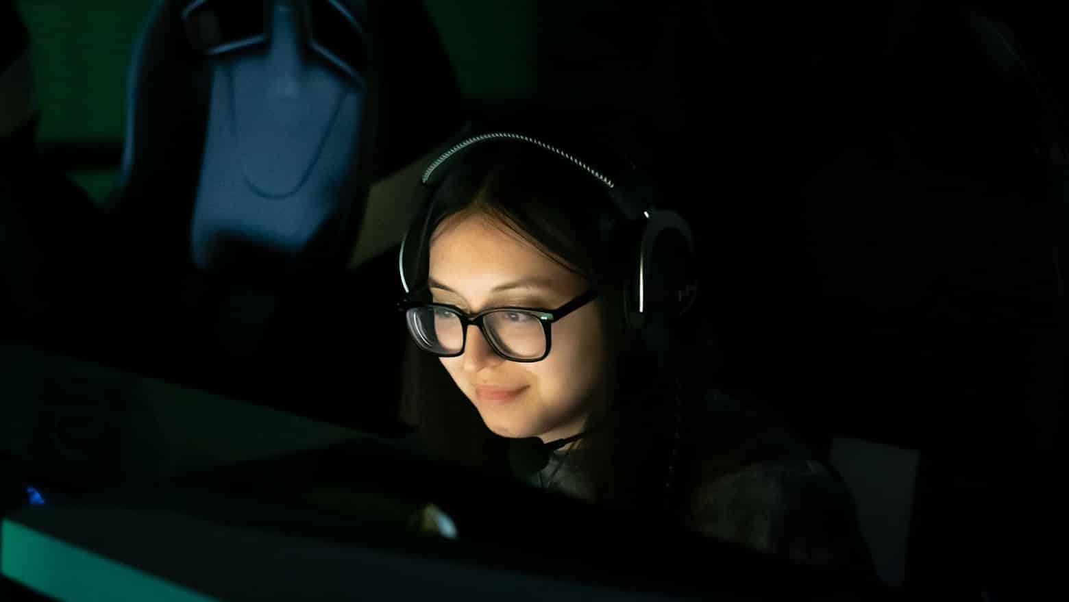 MeL ganz in Schwarz, ihr Gesicht von einem Computerbildschirm beleuchtet